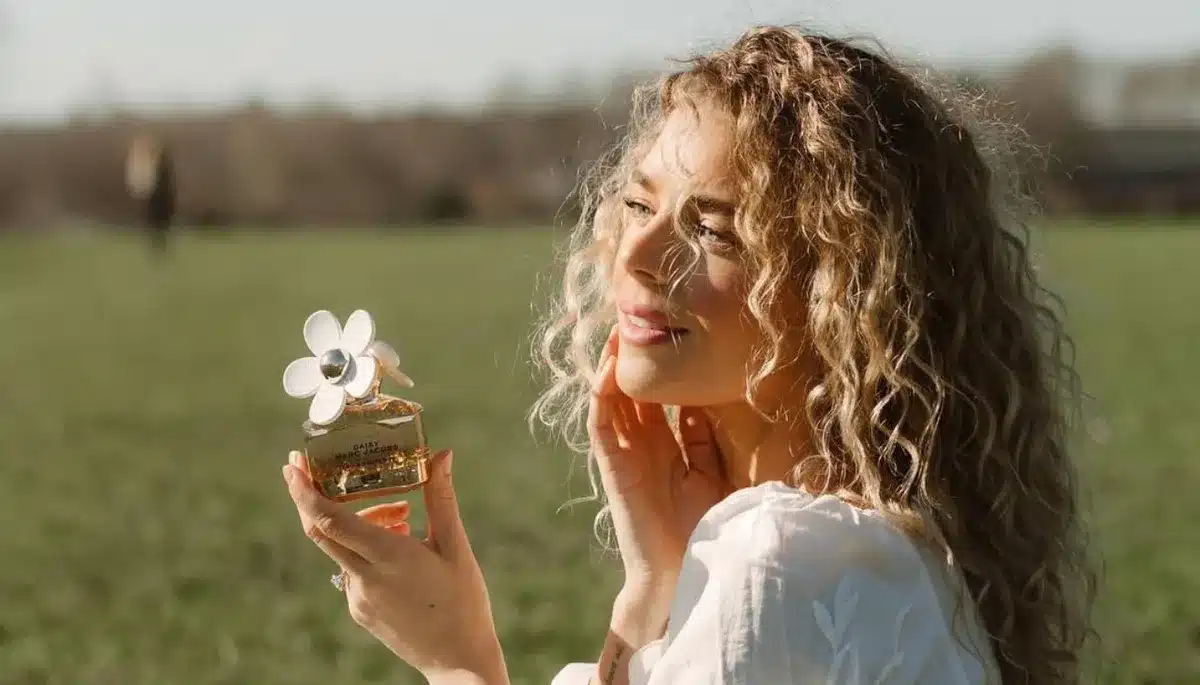Žena drži bočicu parfema